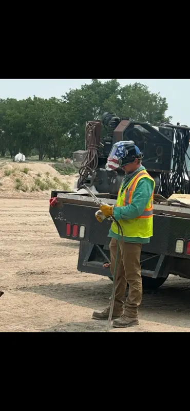 Welder standing by mobile welding rig truck