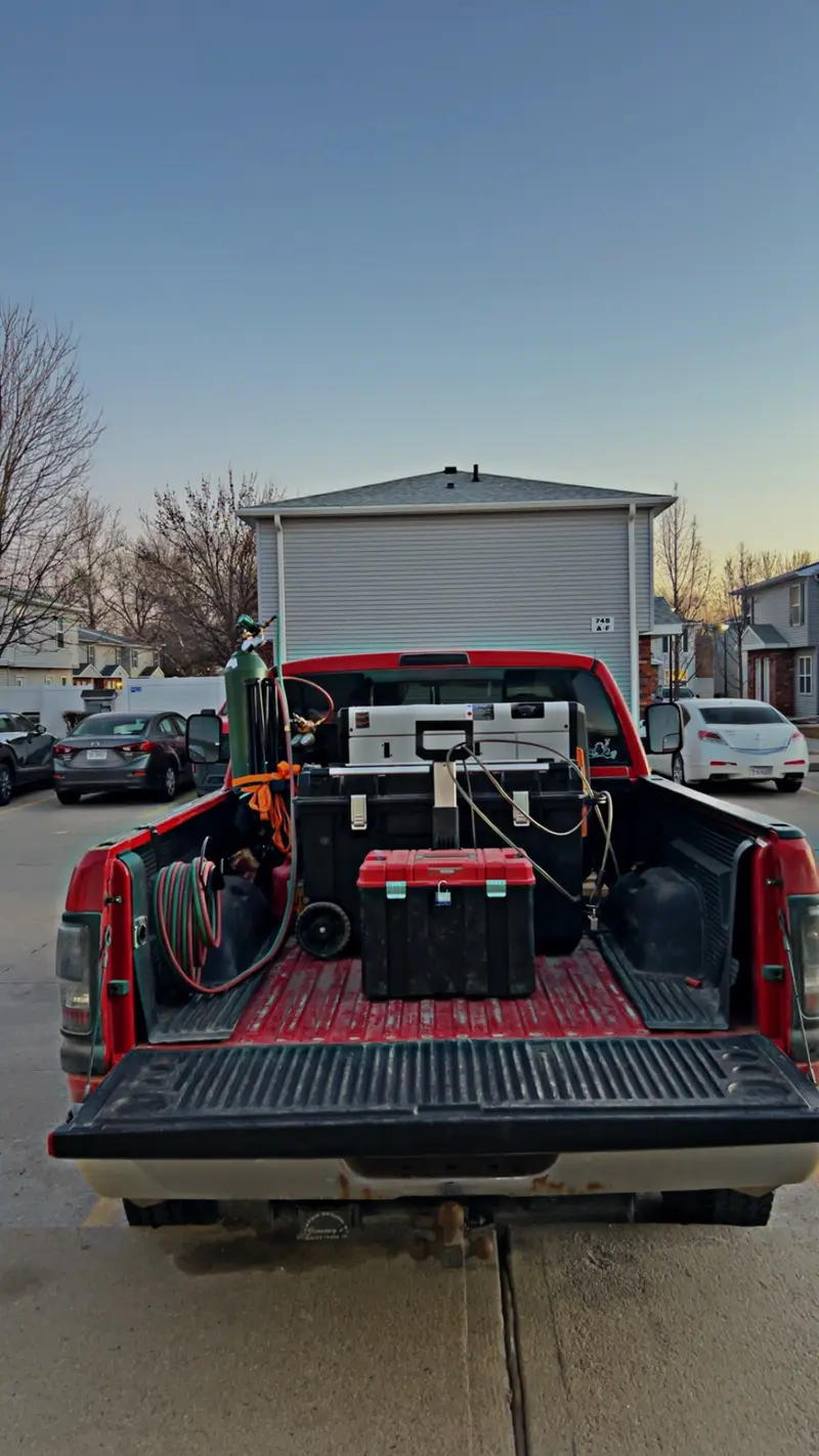Pickup truck bed loaded with welding gear and toolboxes