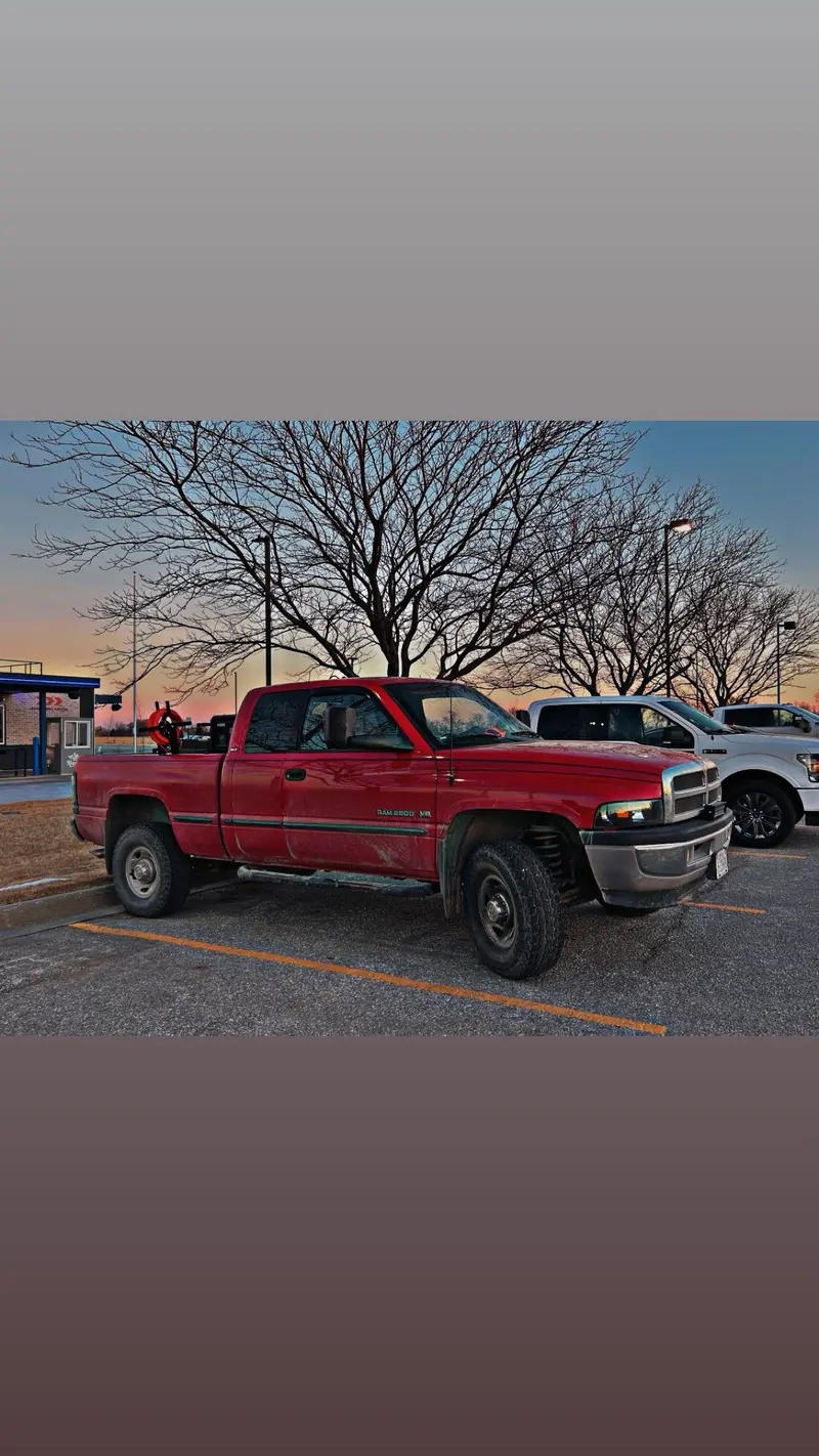 Red Dodge Ram 2500 welding rig truck parked at sunset