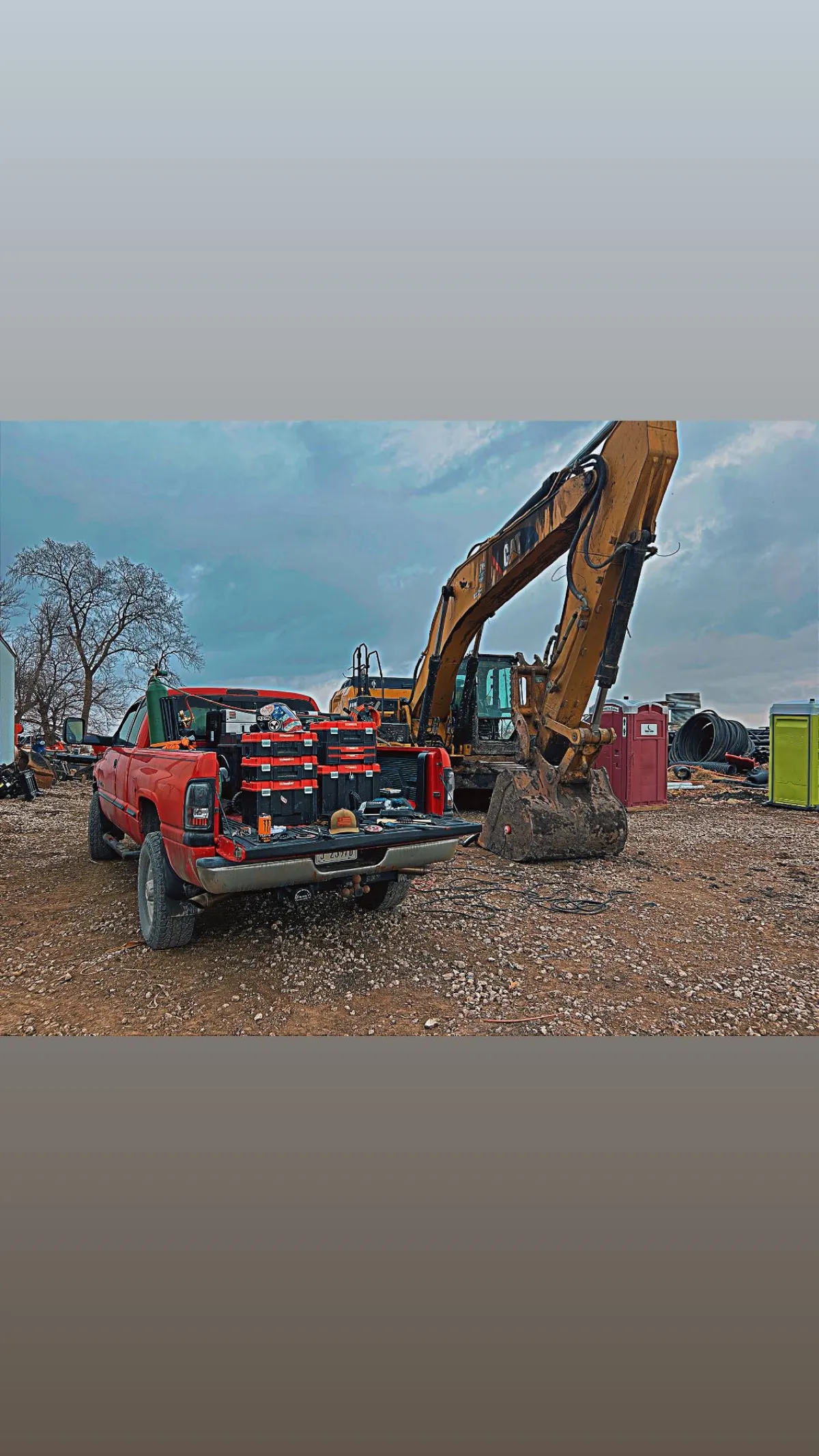 Welding rig truck loaded with tools next to excavator bucket