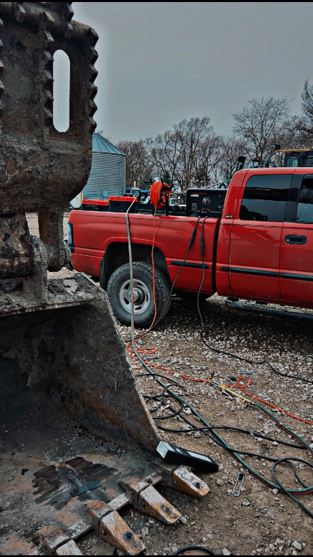 Close-up of excavator bucket repair with welding leads connected